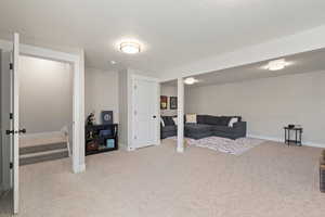 Living room with light colored carpet and a textured ceiling
