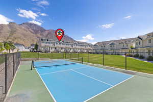 View of tennis court featuring a residential view and a mountain view