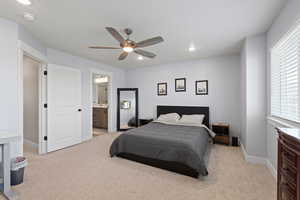 Bedroom featuring a ceiling fan, light carpet, ensuite bath, and recessed lighting
