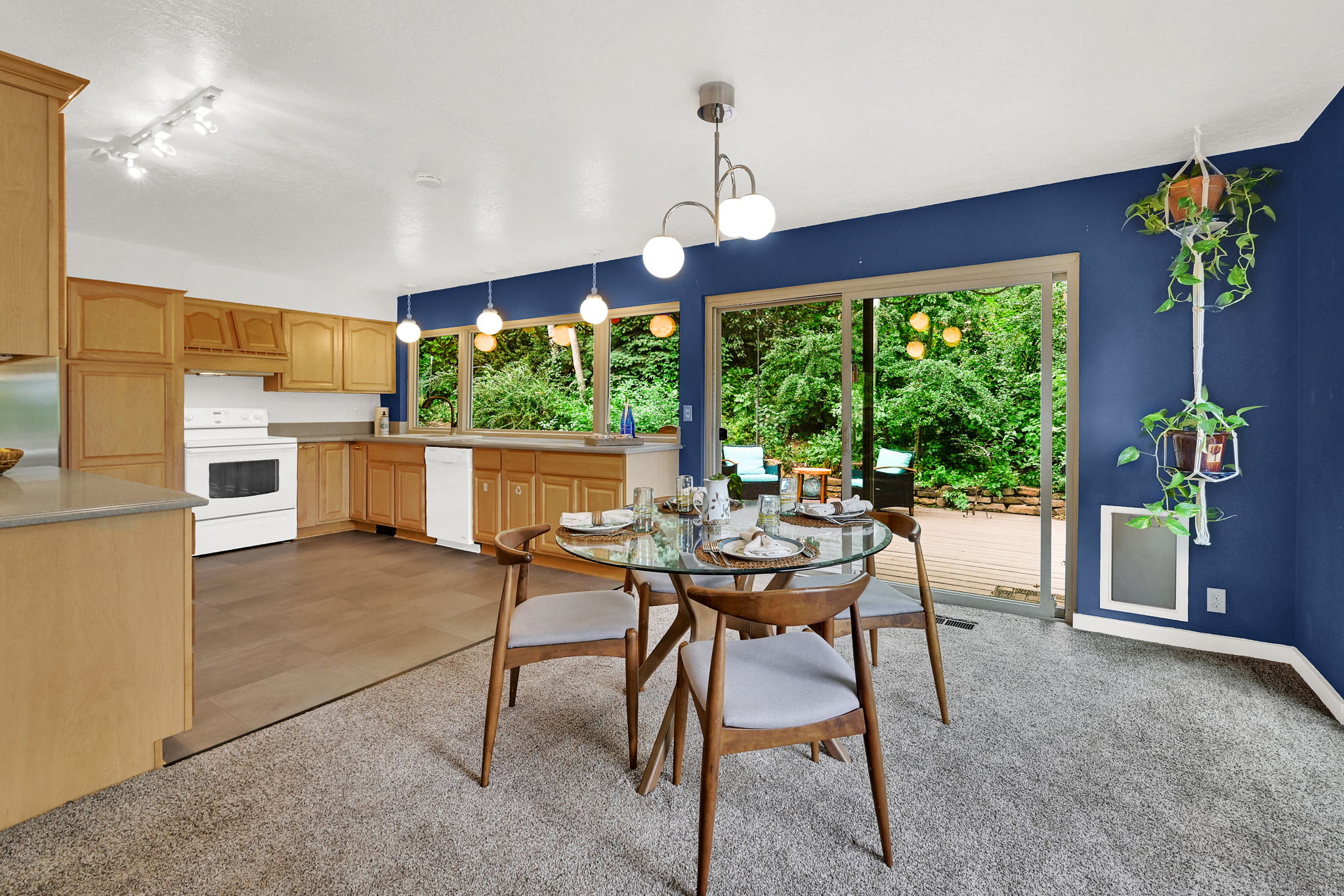 Kitchen and dining areas flow seamlessly to wooded back yard