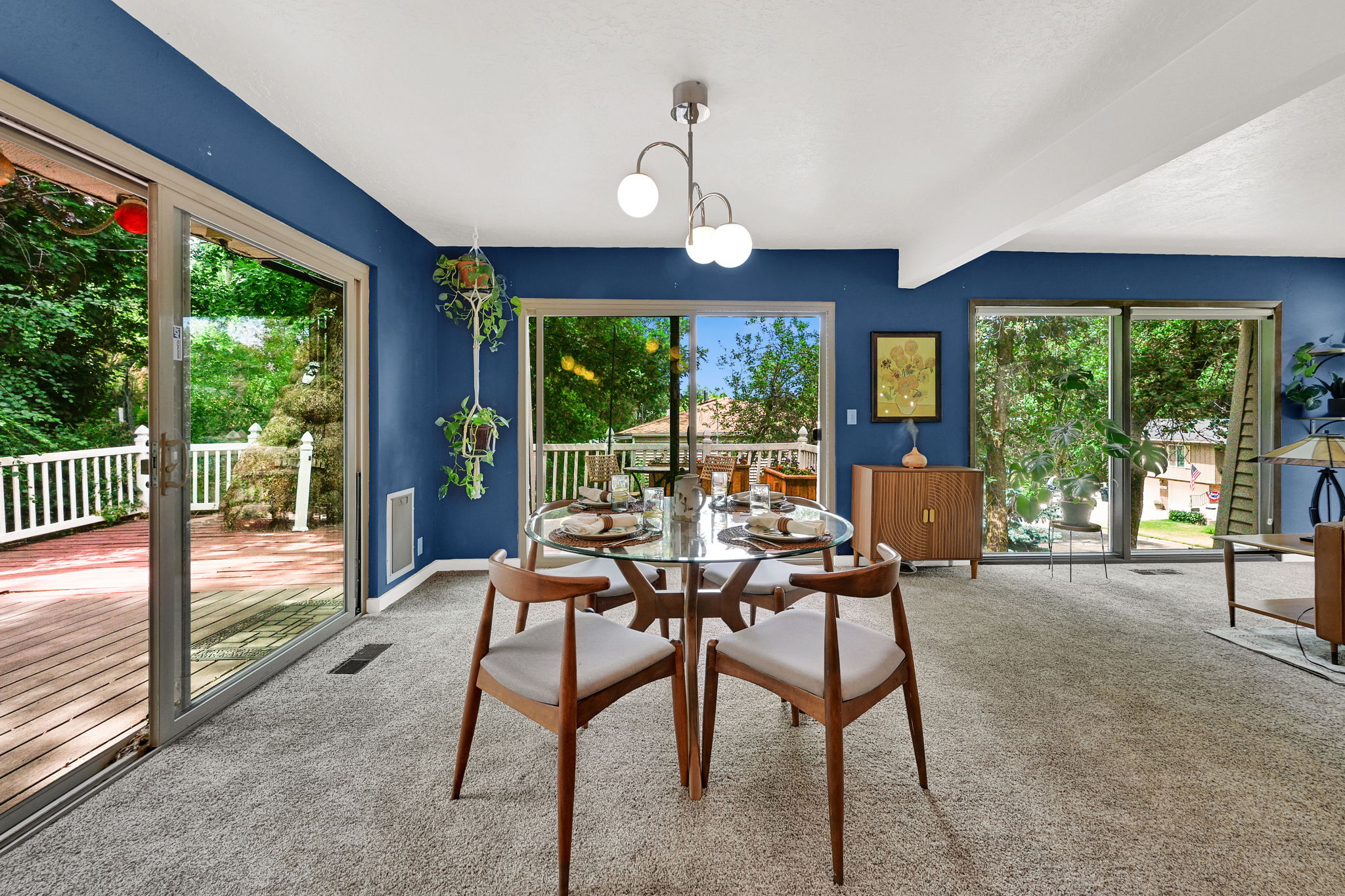 Spacious dining area with oversized sliders on two sides leading to decks.