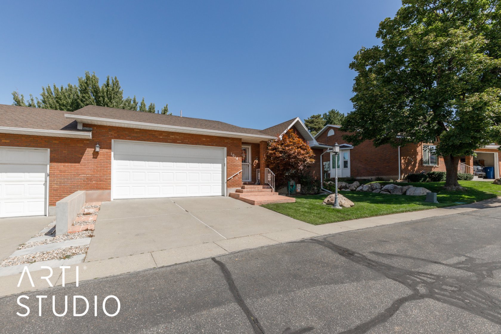 Ranch-style house with a garage, driveway, brick siding, a front lawn, and roof with shingles