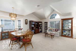 Dining room with lofted ceiling, carpet floors, and suspended lighting