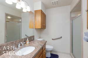 Full bathroom with vanity, a shower stall, and light floors