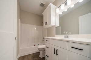 Full bath with vanity, tub / shower combination, and dark wood-type flooring