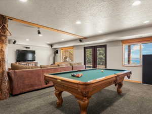 Game room featuring carpet flooring, french doors, a textured ceiling, pool table, and recessed lighting
