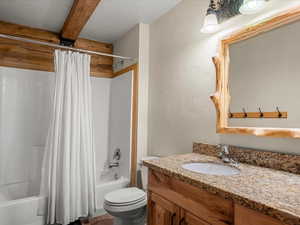 Full bath featuring a textured wall, a textured ceiling, vanity, and shower / tub combo with curtain