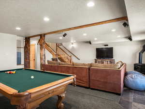Playroom with dark carpet, a wood stove, pool table, a textured ceiling, and recessed lighting