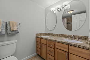 Bathroom with double vanity, a shower with shower curtain, and a textured wall