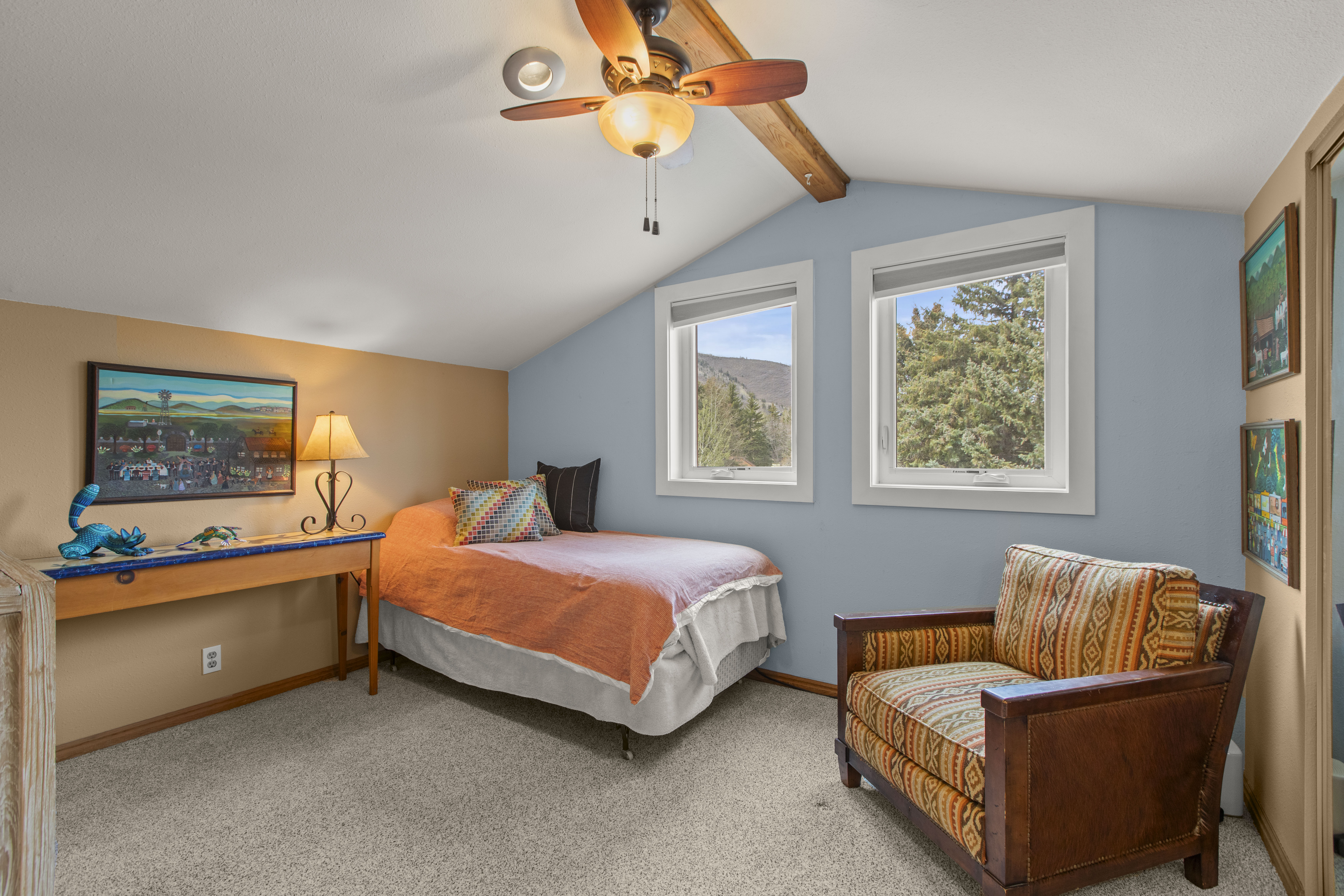 Carpeted bedroom with ceiling fan and beamed ceiling