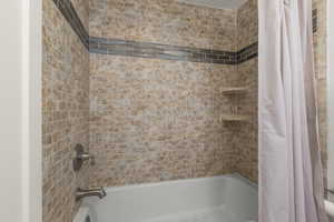 Full bath featuring shower / tub combo with curtain