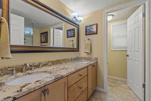 Full bathroom with double vanity and baseboards