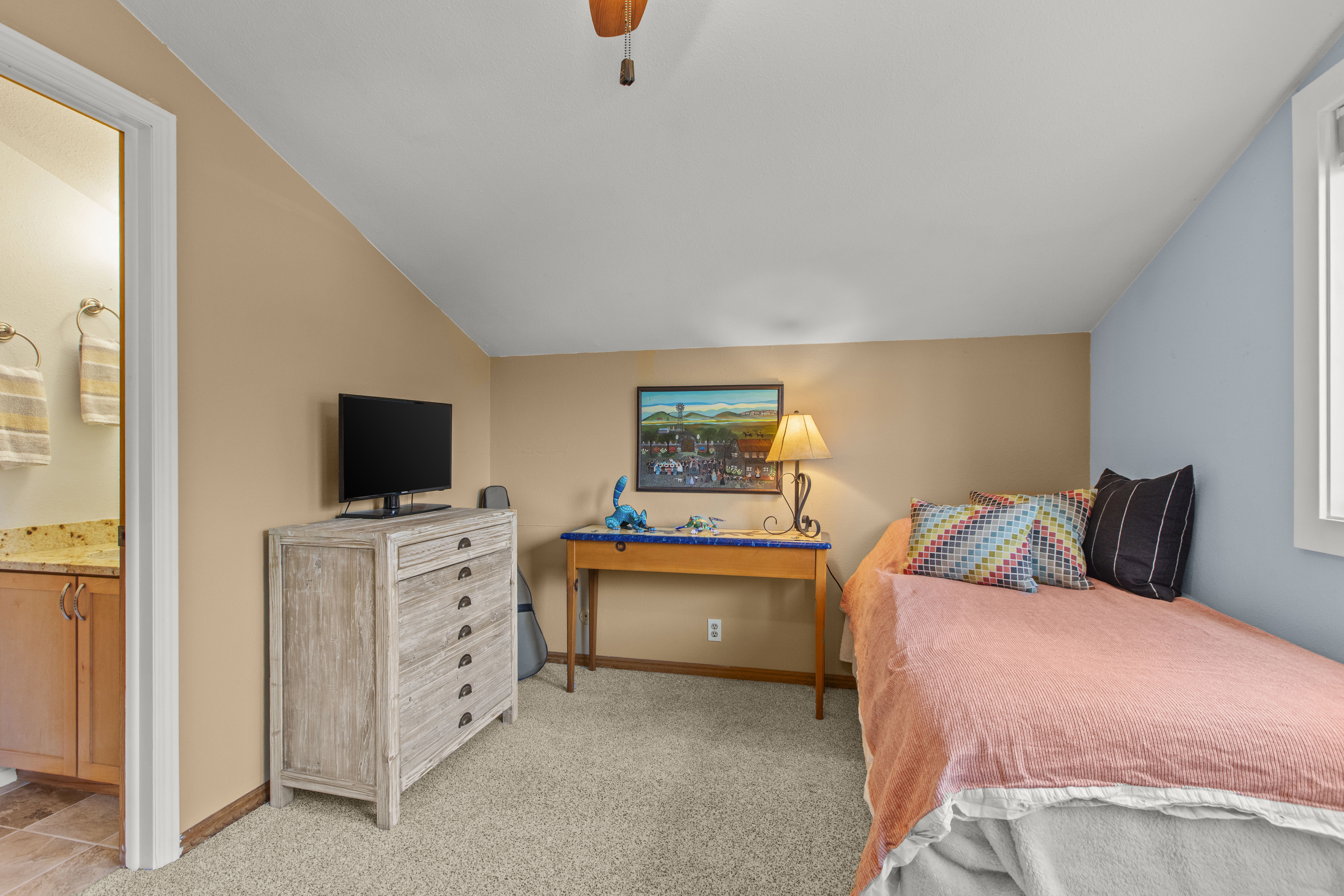 Bedroom featuring vaulted ceiling, carpet floors, a ceiling fan, and ensuite bathroom