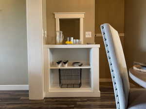 Detailed view of dark wood-style flooring and baseboards and custom built-in shelving