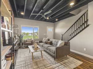 Living area featuring beam ceiling, a ceiling fan, wood finished floors, and recessed lighting