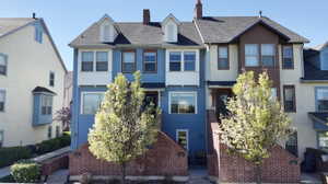 View of front of house featuring a chimney and a shingled roof