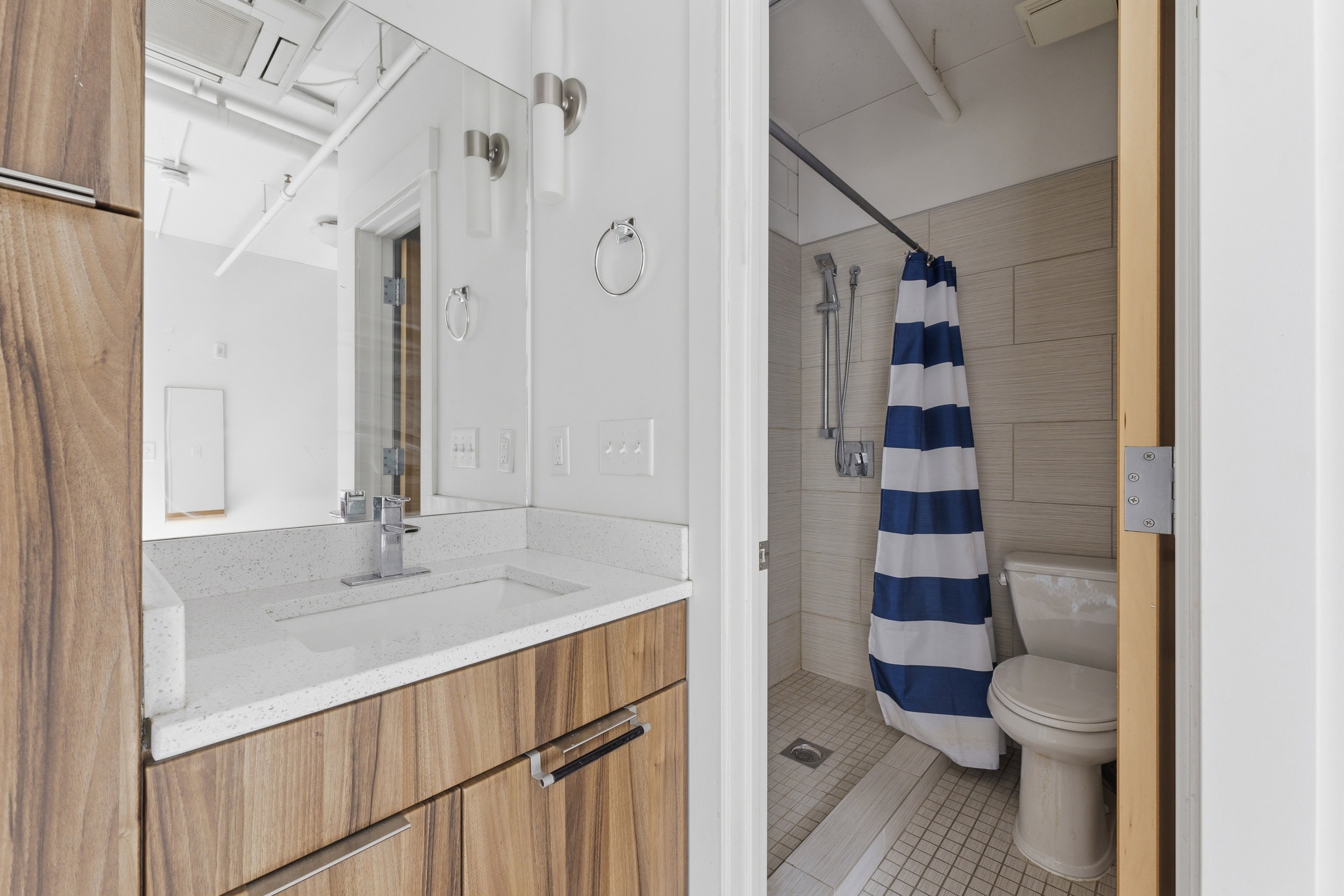 Vanity featuring wood-finish cabinetry, a white countertop with an integrated rectangular sink, and a chrome faucet