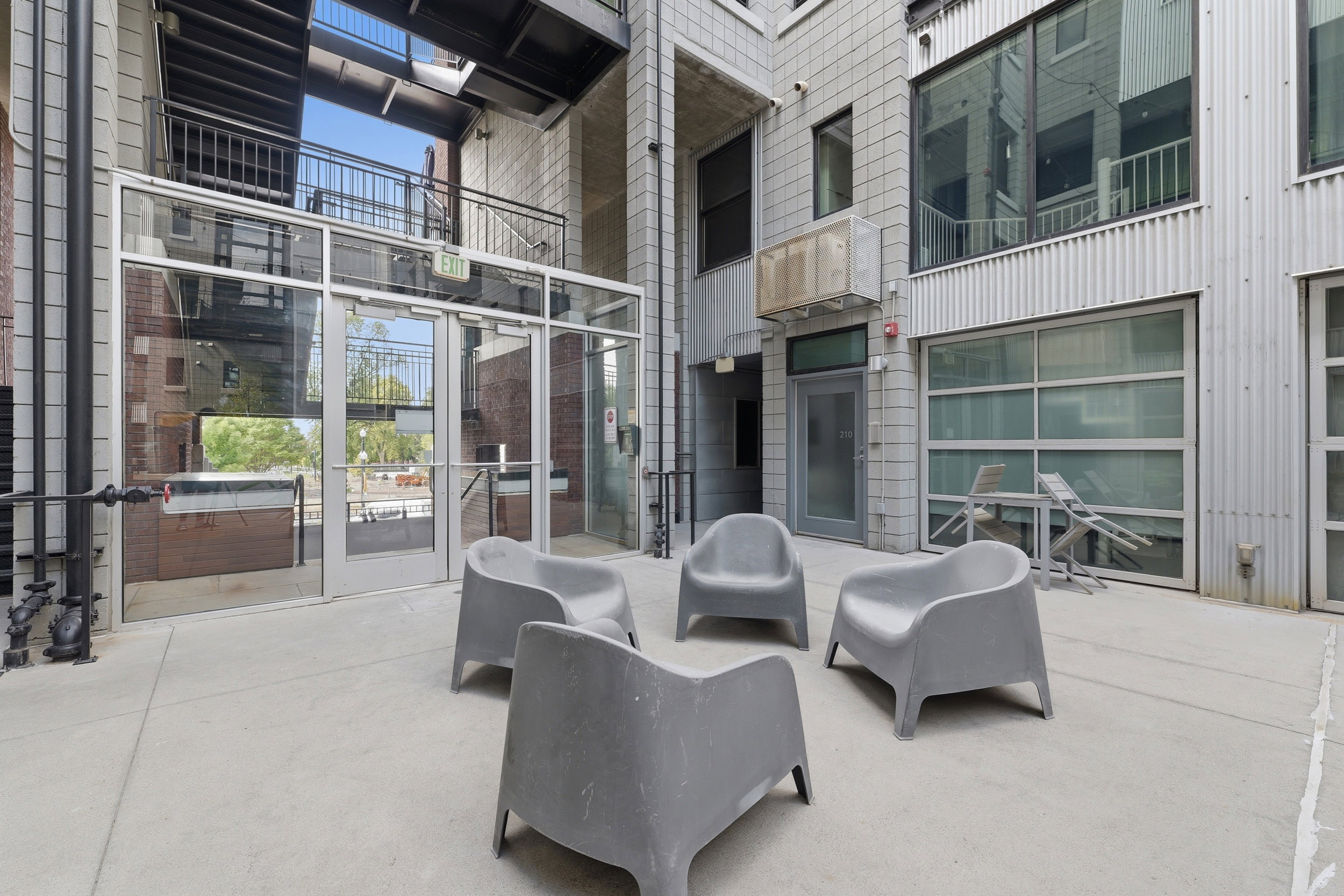 Concrete patio area featuring a multi-level building exterior with industrial design elements