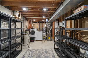 Unfinished basement with washing machine and clothes dryer, secured water heater, electric panel, and heating unit