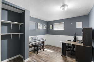 Office space featuring light wood finished floors and a wainscoted wall