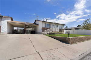Single story home featuring an attached carport, driveway, and brick siding
