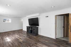 Unfurnished living room featuring dark wood-style flooring, wooden walls, and recessed lighting