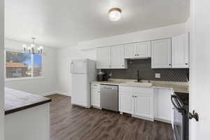 Kitchen featuring white cabinetry, black range with electric stovetop, stainless steel dishwasher, dark wood finished floors, and a textured ceiling