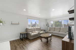 Living area with wood finished floors, recessed lighting, and a textured ceiling