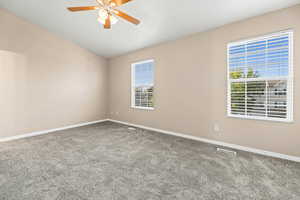 Spacious owner suite with vaulted ceilings, two tone paint, ceiling fan and newer carpet