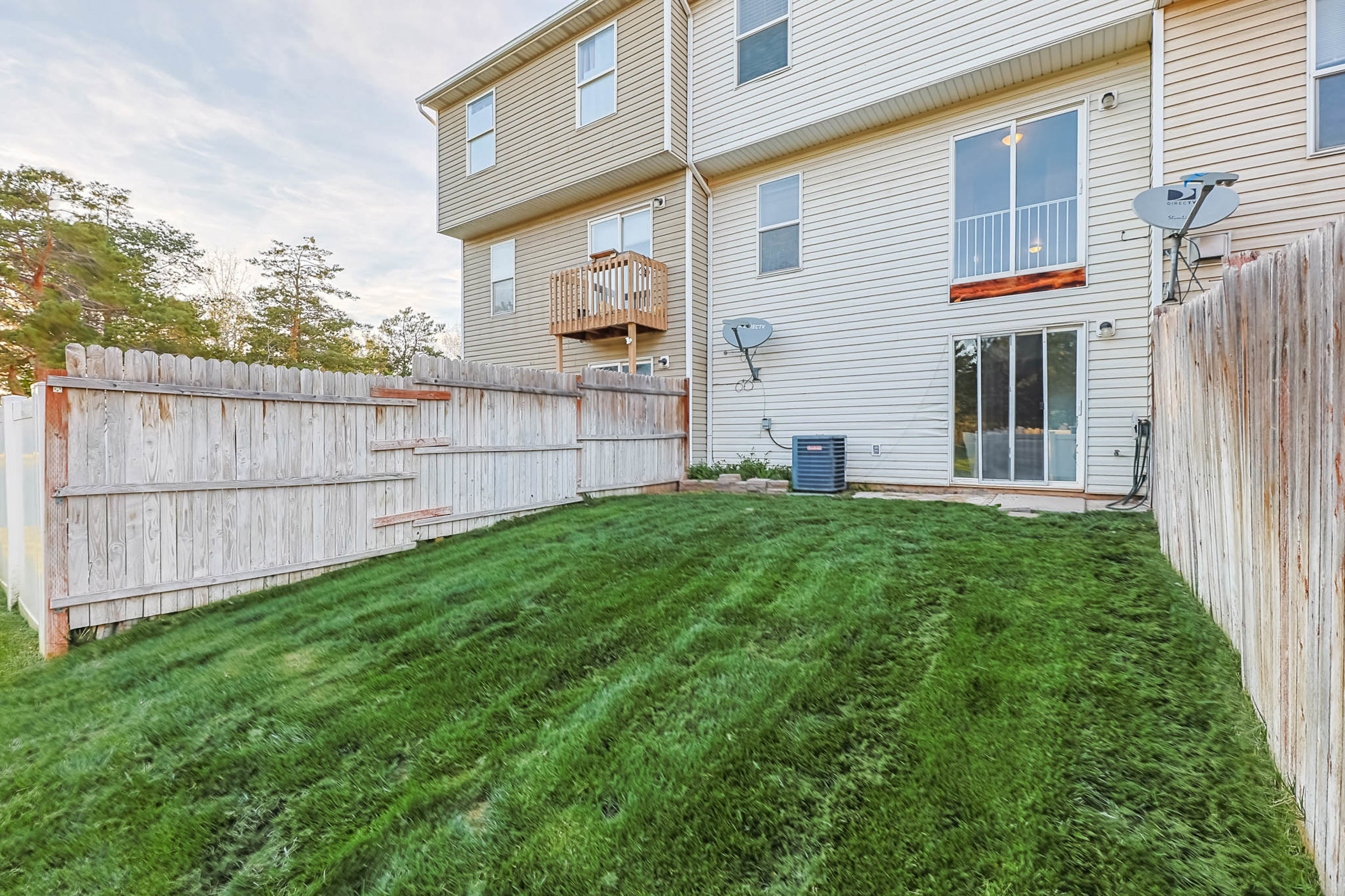 Rear view of house with a partially fenced backyard