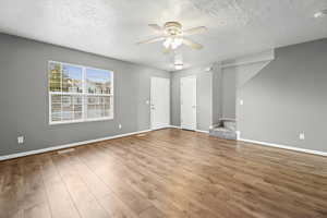 Living room featuring LVP flooring, two-tone paint and ceiling fan