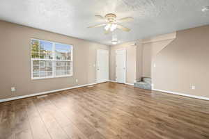 Living room featuring two tone paint, ceiling fan, and LVP flooring