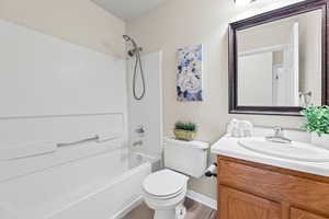 Bathroom with vanity, washtub / shower combination, tile flooring, updated mirror and light fixture