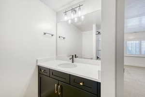 Bathroom featuring vanity, light carpet, and a textured ceiling