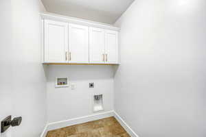 Laundry area featuring hookup for an electric dryer, washer hookup, cabinet space, and a textured ceiling