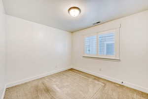 Unfurnished room with light carpet and a textured ceiling