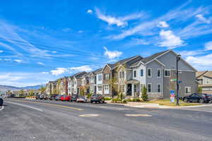 View of asphalt road featuring a residential view, curbs, and a mountain view