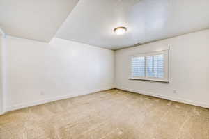 Unfurnished room with light carpet and a textured ceiling