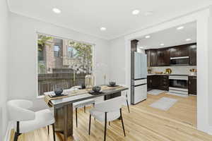 Dining room with recessed lighting, light wood-style floors, and crown molding