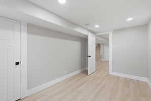 Finished below grade area featuring recessed lighting and light wood-style floors