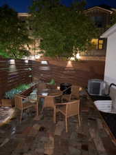 Private courtyard featuring a flagstone patio, wood fence with integrated lighting, and built-in planters