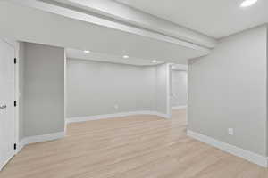 Finished below grade area featuring light wood finished floors and recessed lighting