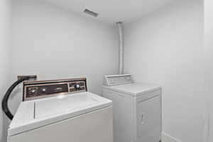 Laundry room with separate washer and dryer and baseboards