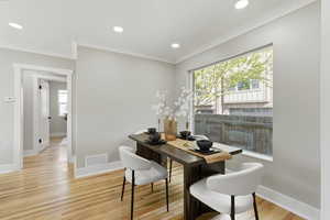 Dining area with light wood-style flooring, ornamental molding, and recessed lighting