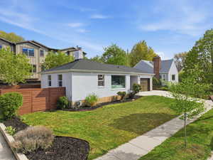 View of front of property featuring an attached garage, concrete driveway, brick siding, roof with shingles, and a sunroom
