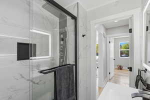 Bathroom featuring a marble finish shower, vanity, and light wood-type flooring
