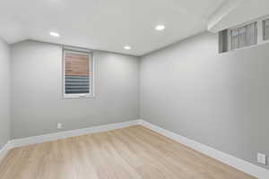Empty room with light wood-style floors and recessed lighting