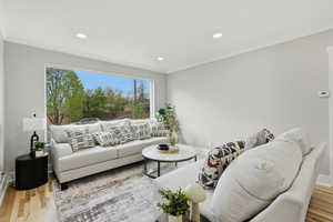 Living area with light wood-type flooring, recessed lighting, and crown molding