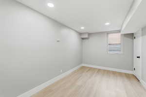 Below grade area featuring light wood-style flooring and recessed lighting