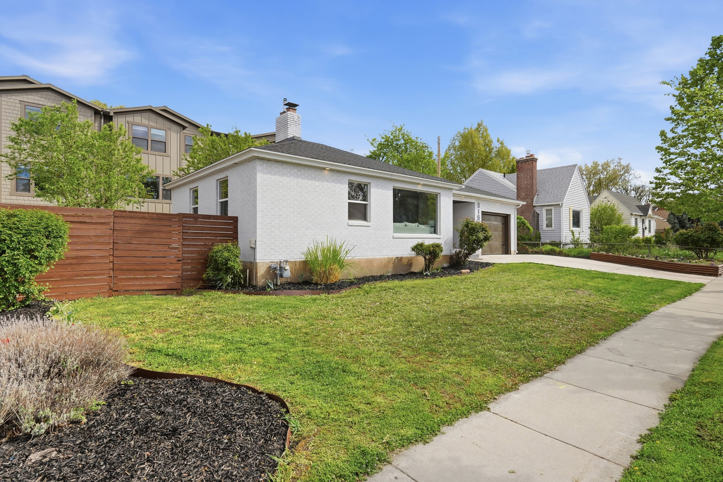 View of front facade with concrete driveway, an attached garage, and a chimney